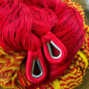 Mexikanische Hängematte in Detailansicht. Zu sehen sind die Details der einzelnen Fäden und die beiden mit Metall verstärkten Aufhänge-Schlaufen. Farben der Hängematte: Rot und Gelb (Variante Tequila-Farben im Shop). Die Hängematte wurde in Yucatan / Mexiko per Hand gewebt.
